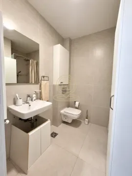 Modernly equipped bathroom with a washbasin, toilet, and mirror. - image 6