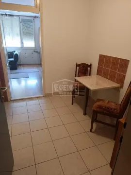 Manja kuhinja sa trpezarijskim stolom i stolicama i pogledom na susednu prostoriju. - image 3