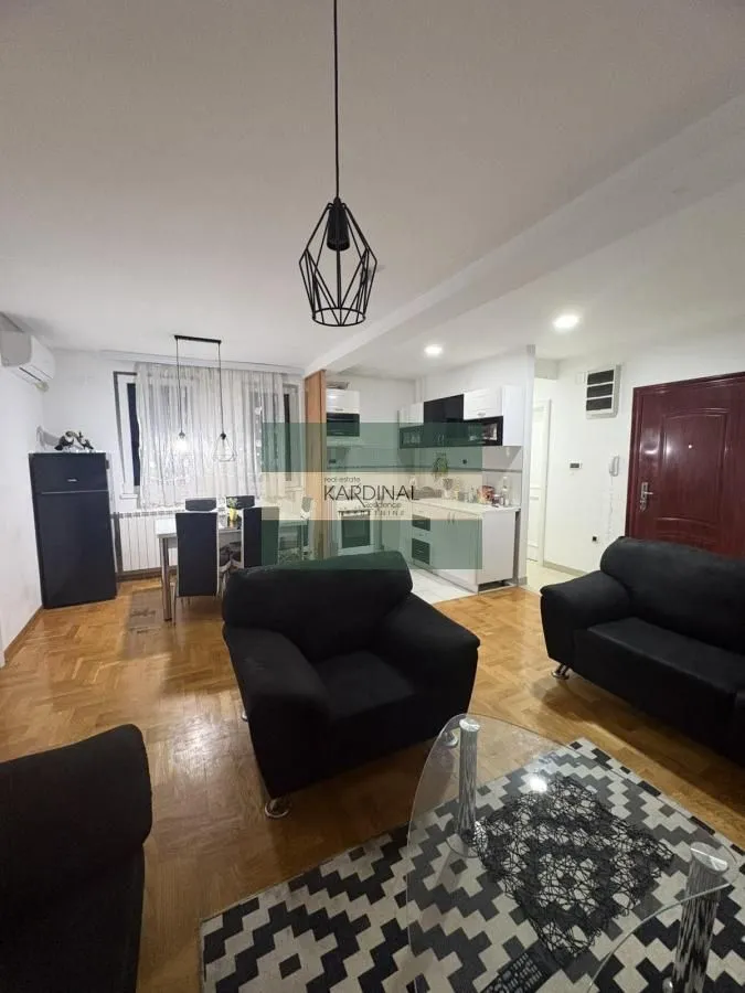 Living room with sofa set, dining area, and kitchen in the background.