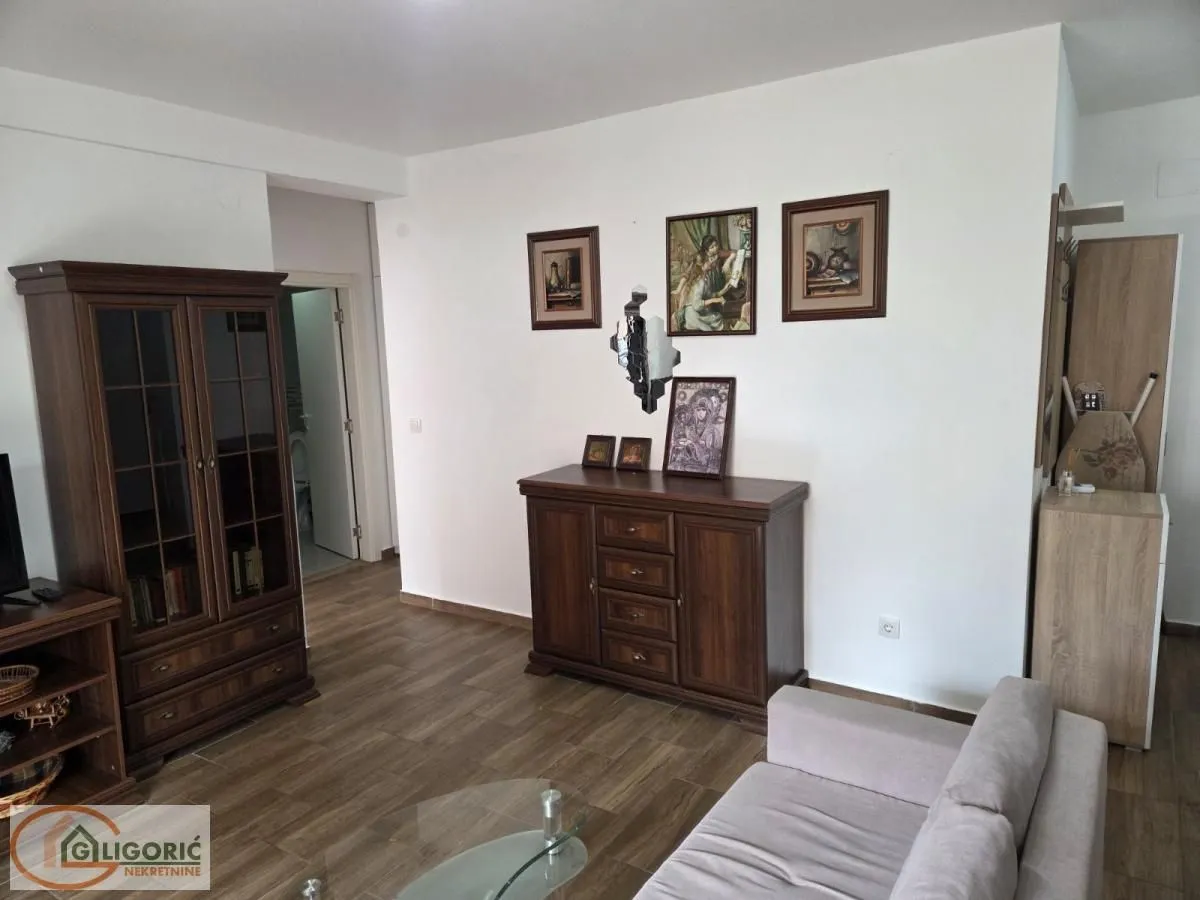 Living room with sofa, wooden furniture and pictures on the wall.