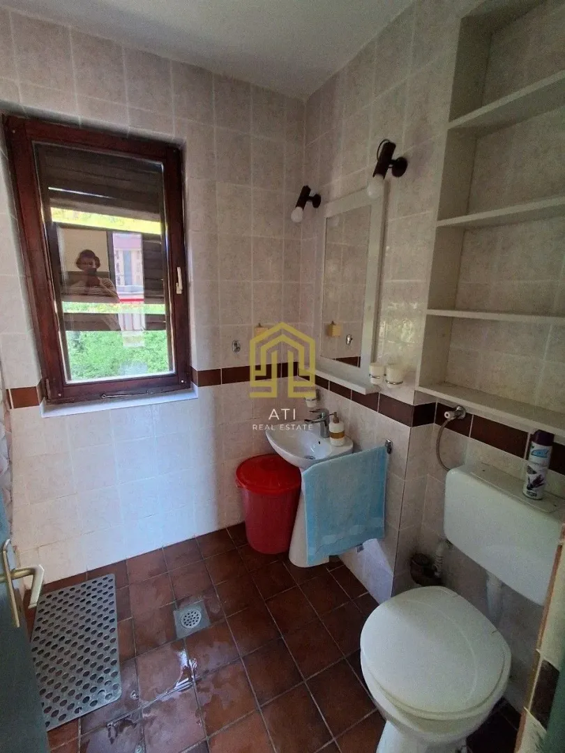 Manje kupatilo sa sanitarijama i pločicama u braon tonovima.