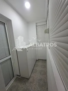 Enclosed balcony with a white cabinet and window shutters. - image 5