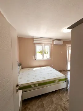 Spavaća soba sa bračnim krevetom, prozorom i klima uređajem. - image 3