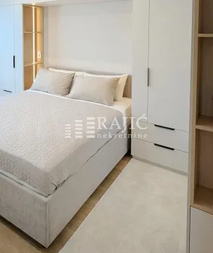 Modern bedroom with a double bed and built-in light-colored wardrobes. - image 8