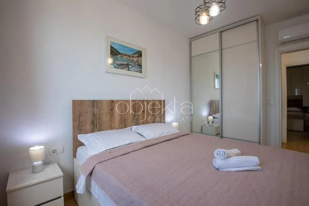 Bedroom with a double bed, nightstand, and a built-in wardrobe with a mirror.