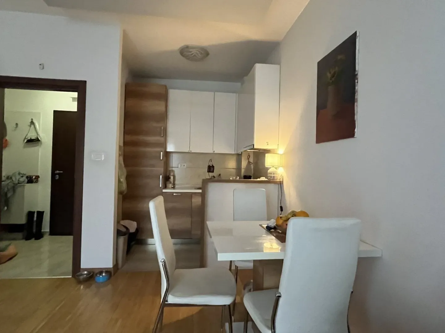 Svijetla kuhinja sa trpezarijskim stolom i stolicama u modernom stanu.