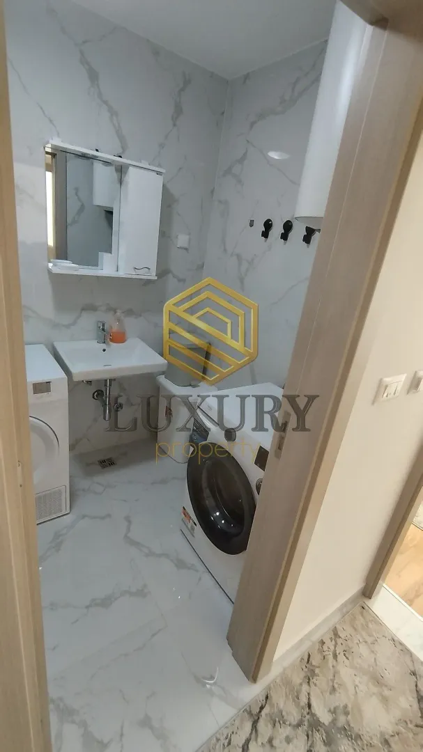 Modernly equipped bathroom with a washing machine.