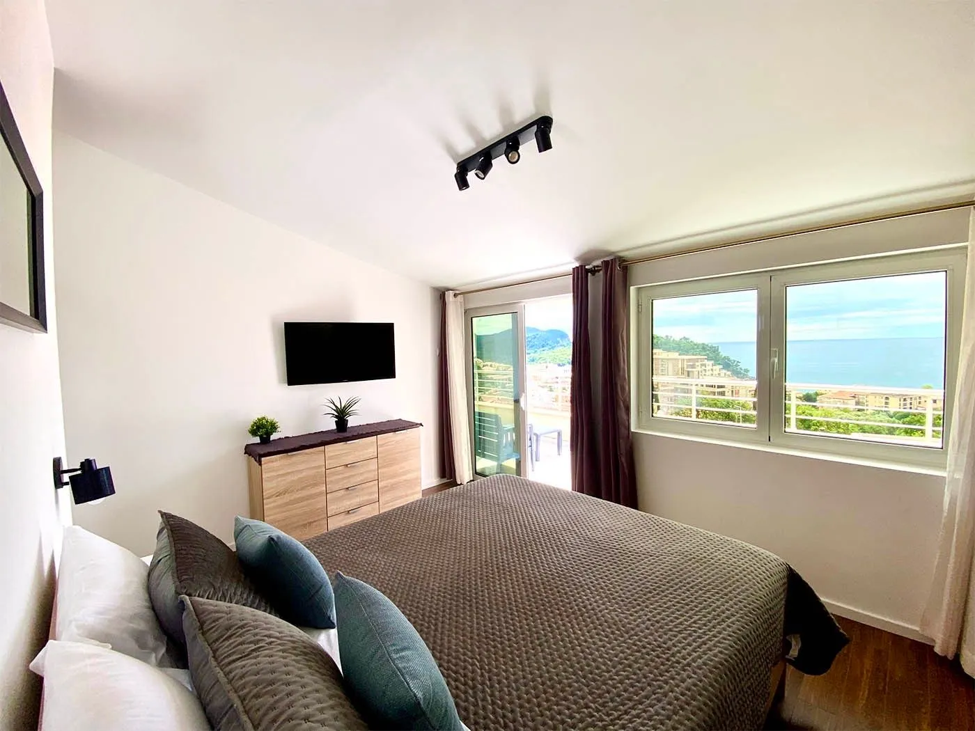 Bright bedroom with a double bed and a sea view.