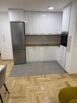 Manja kuhinja sa belim elementima, ugradnim uređajma i frižiderom. - image 3