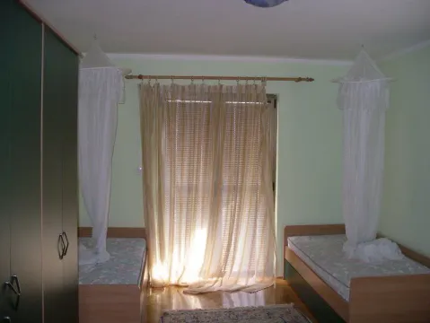 Spavaća soba sa dva kreveta i ormarom. - image 3