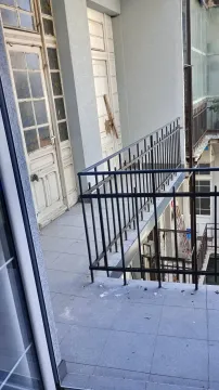 Pogled na spoljašnji balkon sa metalnom ogradom i starim drvenim vratima. - image 8