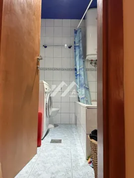 Pogled na kupatilo sa kadom, veš mašinom i toaletom kroz otvorena vrata. - image 2