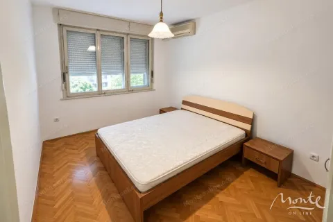Spavaća soba sa bračnim krevetom i drvenim podom. - image 4