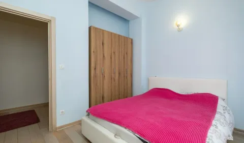 Spavaća soba sa bračnim krevetom i drvenim ormarom. - image 6