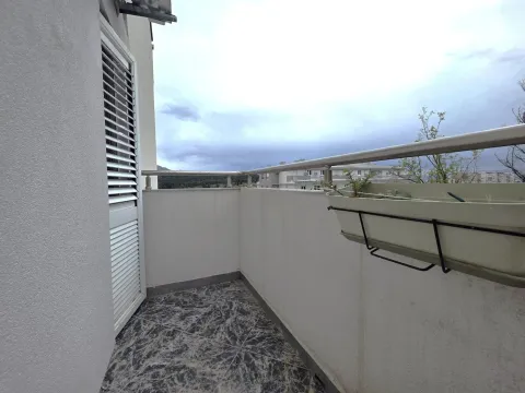 Covered balcony space with tiled flooring and a protective railing. - image 6