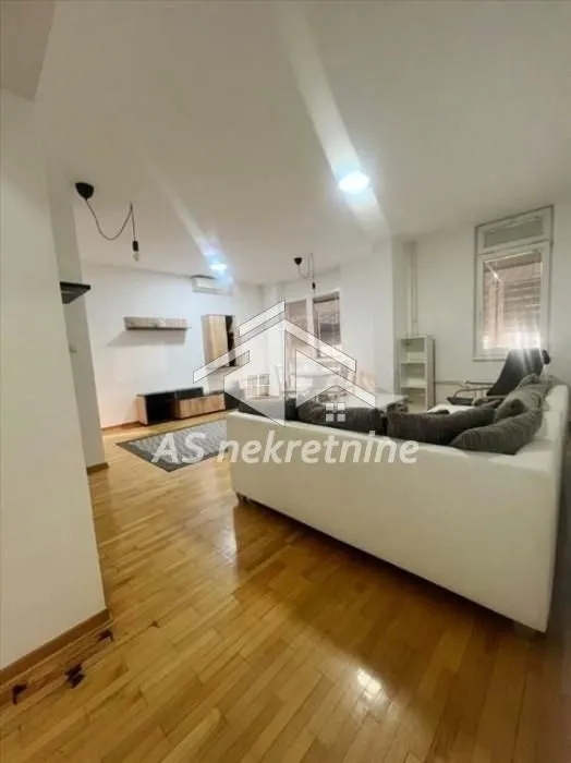 Living room with a sofa and wooden flooring.