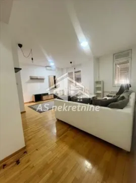 Living room with a sofa and wooden flooring. - image 4