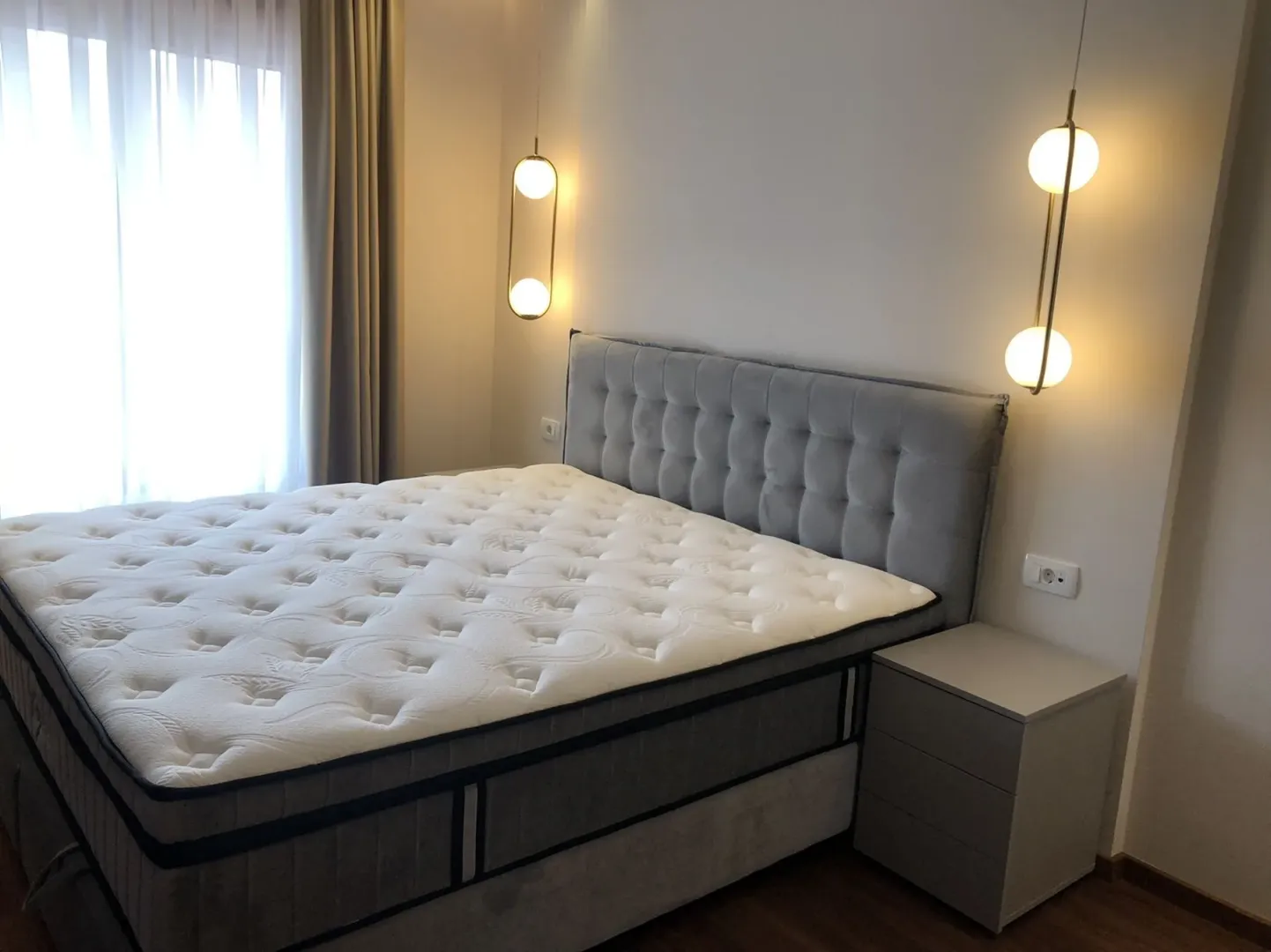 Bright bedroom with a modern bed and lighting.
