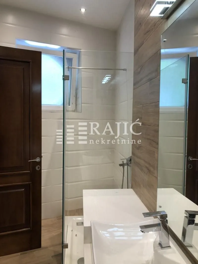 Modernly equipped bathroom with a walk-in shower and washbasin.