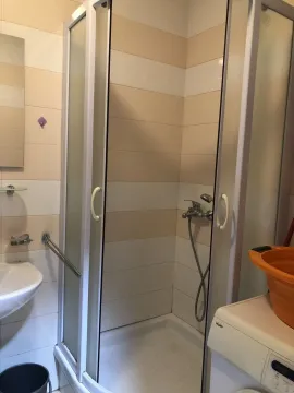 Bathroom with a shower cabin and a washing machine. - image 8