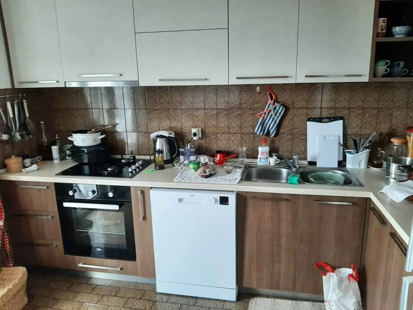 Kuhinja sa svijetlim i drvenim kuhinjskim elementima i ugradnim uređajima.