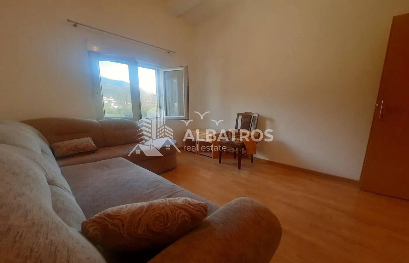 Living room with a sectional sofa and a window overlooking nature.