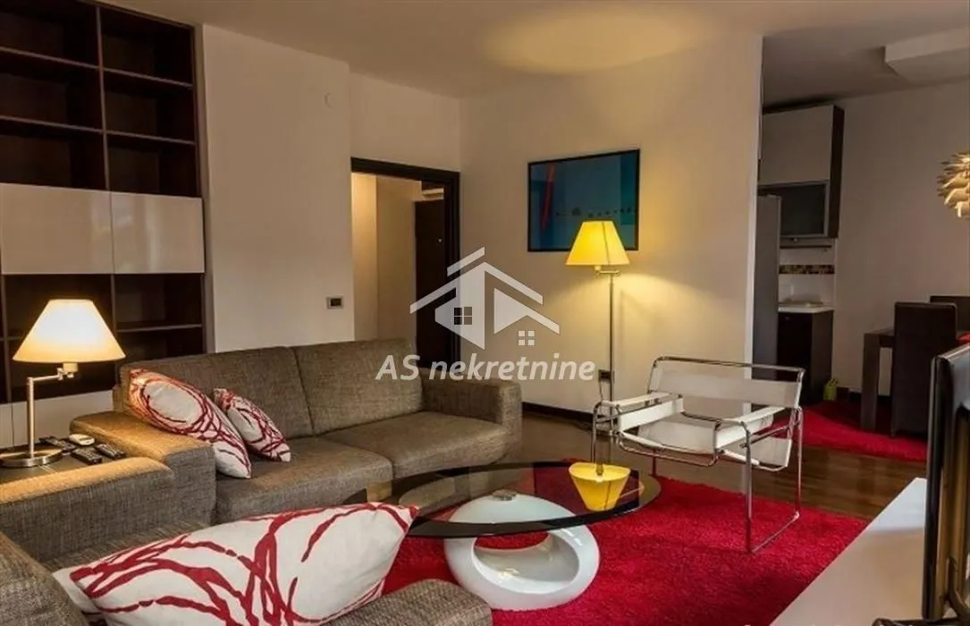 Furnished living room with a sofa and shelving units.