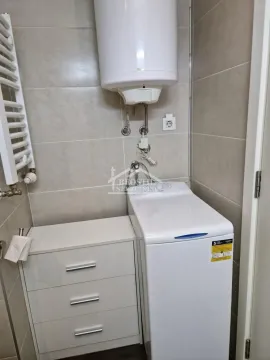 Bathroom equipped with a washing machine, water heater, and a white chest of drawers. - image 9