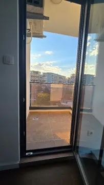 View through the balcony door to the terrace and surrounding buildings. - image 16