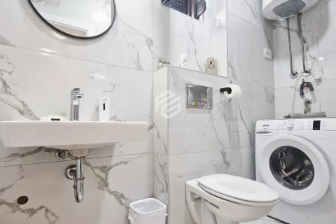 Small bathroom with white marble-effect ceramic tiles, washbasin and washing machine. - image 8