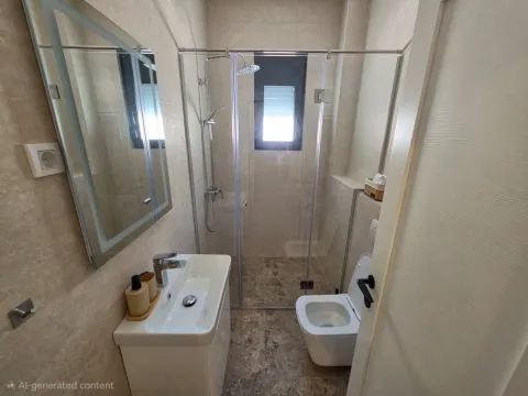 Modern bathroom with a sink, shower cabin, and toilet. - image 2