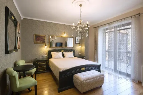 Bedroom with a double bed and a decorative chandelier. - image 5