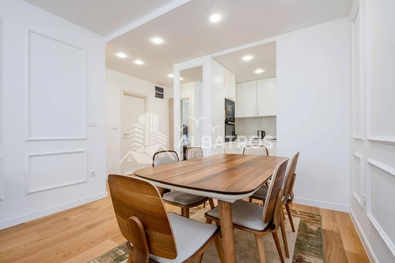 Dining area with a wooden table and chairs, connected to the kitchen.