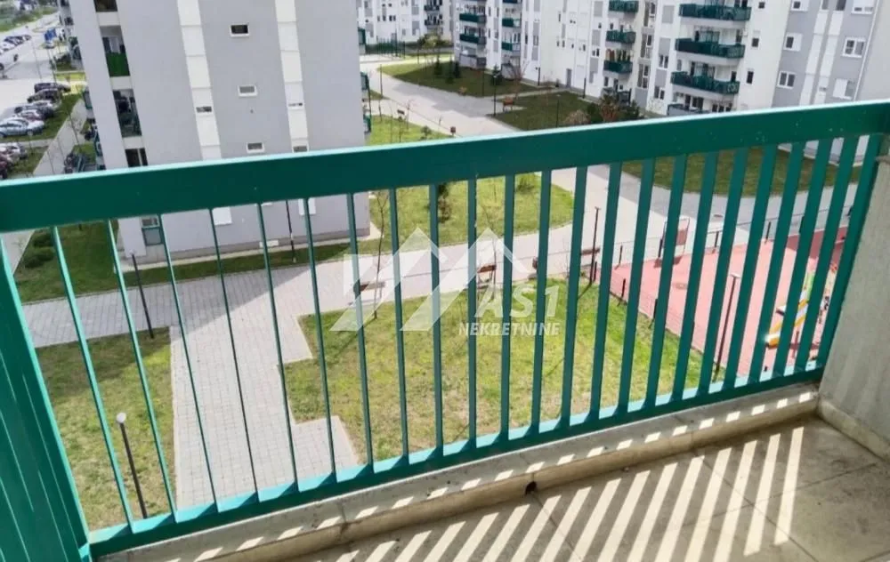Pogled sa balkona na dvorište i okolne zgrade.