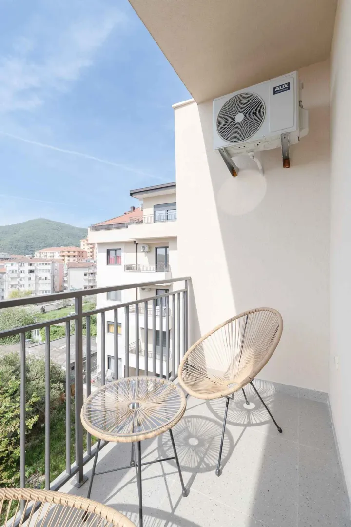 Manji natkriveni balkon sa garniturom za sjedenje i klimom.