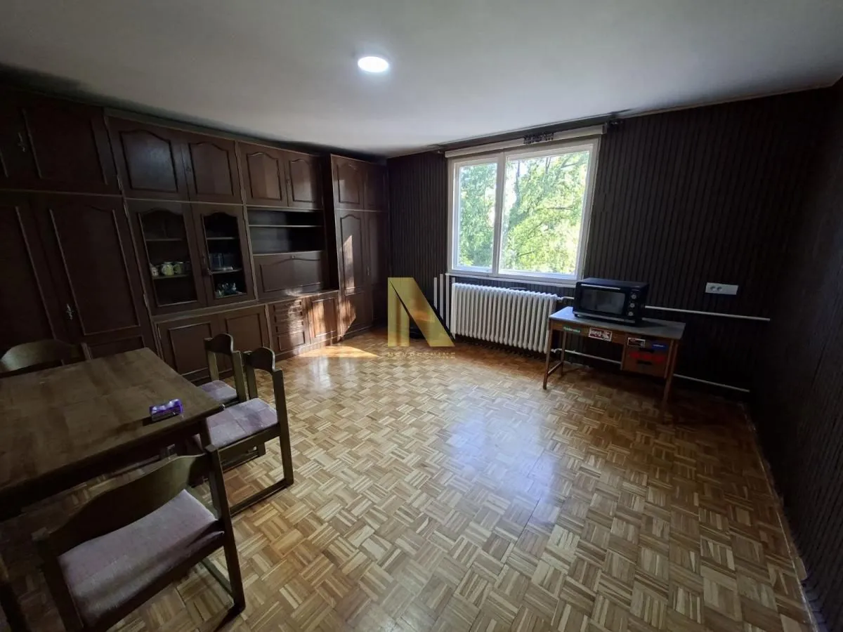 Spacious living room with wooden furniture and parquet flooring.