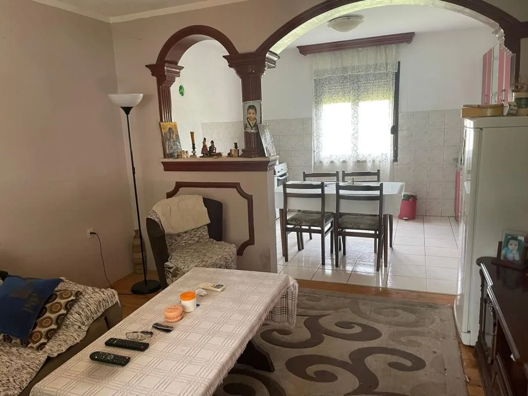 Living room with a view of the dining area and kitchen in the background.