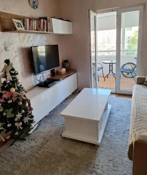 Dnevna soba sa garniturom, televizorom i izlazom na terasu. - image 6
