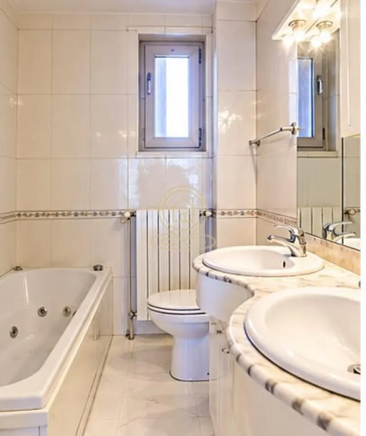 Bathroom equipped with a bathtub, toilet, and double sink.