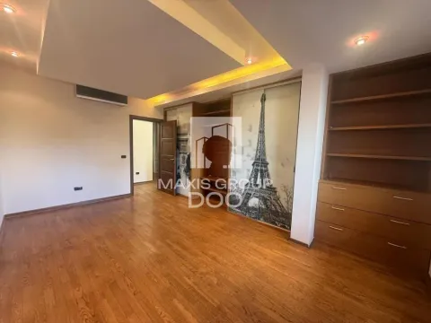Bedroom with hardwood flooring, built-in wardrobe featuring an Eiffel Tower motif, and shelving units. - image 5
