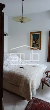 Nameštena spavaća soba sa bračnim krevetom i umetničkom slikom na zidu. - image 4