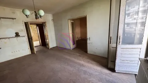 Prazna dnevna soba sa parketom i vratima koja vode u druge prostorije. - image 3