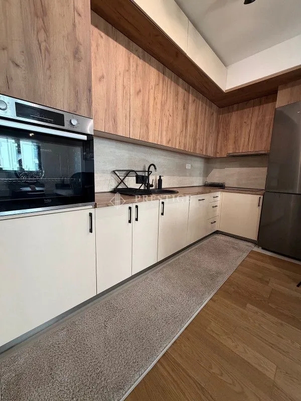 Modern kitchen with wooden cabinetry and built-in oven.