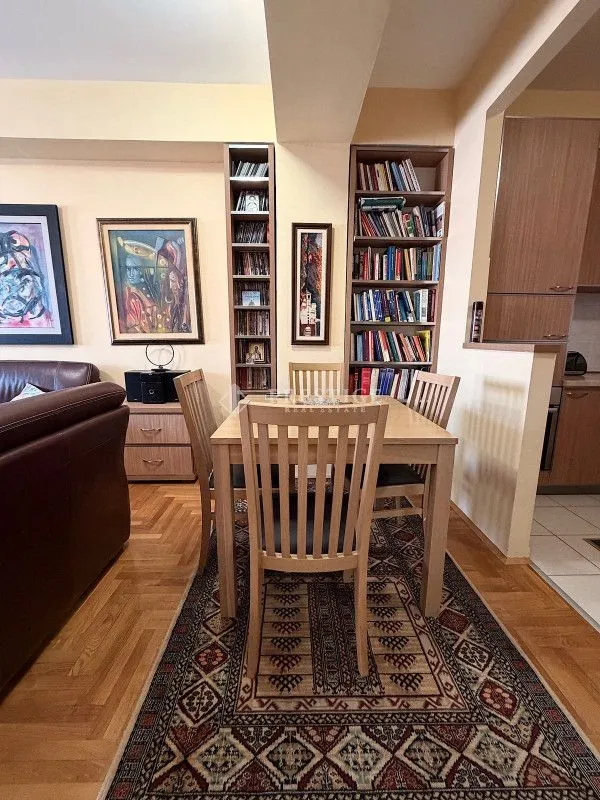 Dining area with a wooden table and chairs, connected to the living room and kitchen.