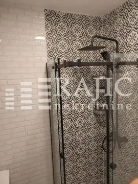Modern bathroom with a walk-in shower and decorative tiles. - image 10