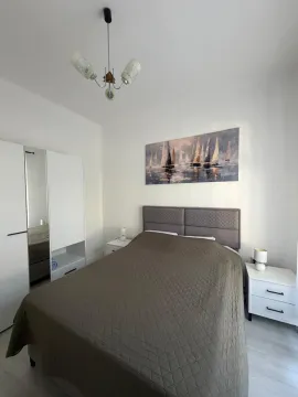 Namještena spavaća soba sa bračnim krevetom, bijelim ormarom i noćnim stočićima. - image 7