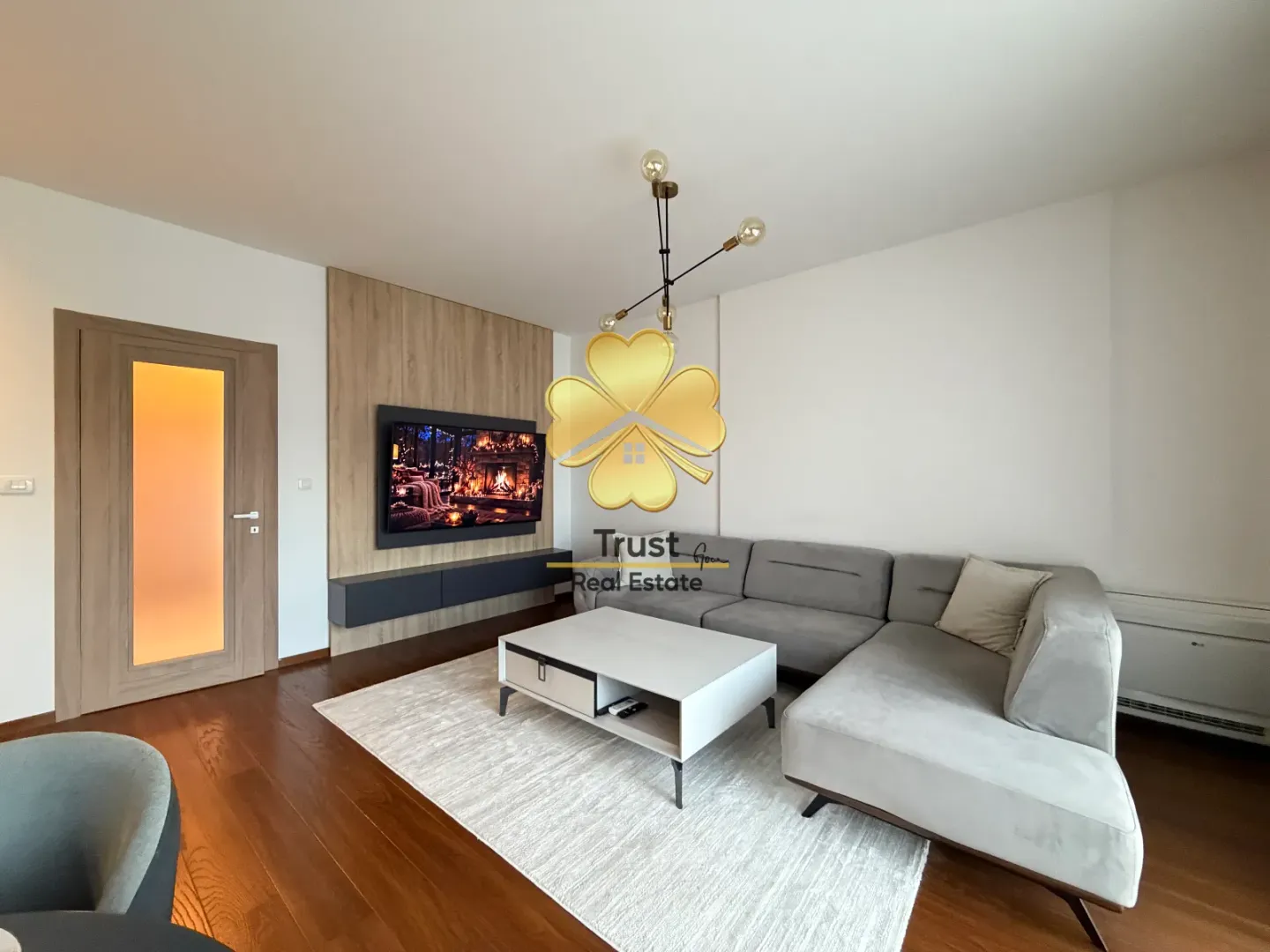 Modern living room with a sofa, coffee table, and wall-mounted TV.