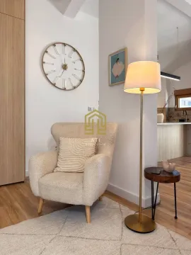 Comfortable armchair with a floor lamp and a decorative wall clock in the living room. - image 5