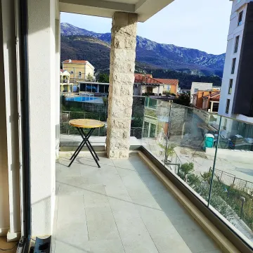 Prostrana popločana terasa sa staklenom ogradom i pogledom na okolinu. - image 6