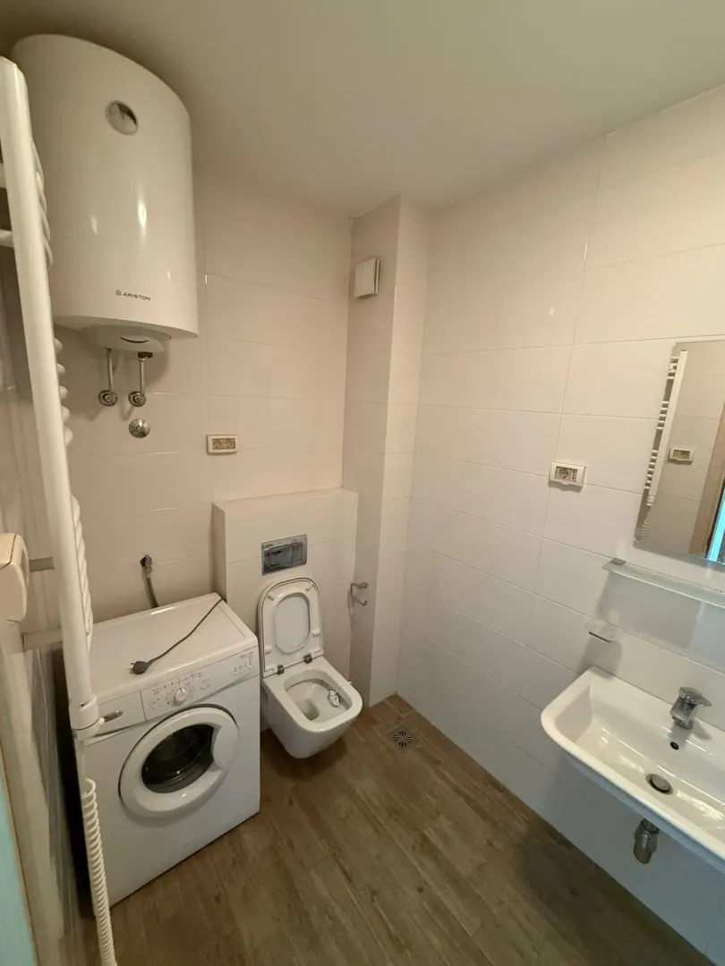 Kupatilo opremljeno sanitarijama, umivaonikom, veš mašinom i bojlerom.